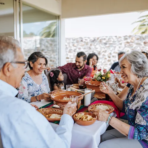 Family gathering around a table enjoying a meal, illustrating the importance of community and support in estate planning and probate law discussions.